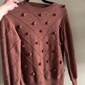 Brown sweater with cute detail.
